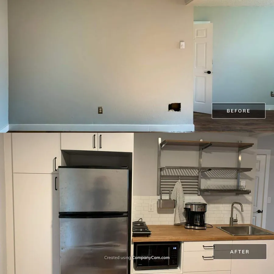 Before and after: a bare lower-level wall turned into a cooking wall with a refrigerator, sink, butcher block counter, and open shelving